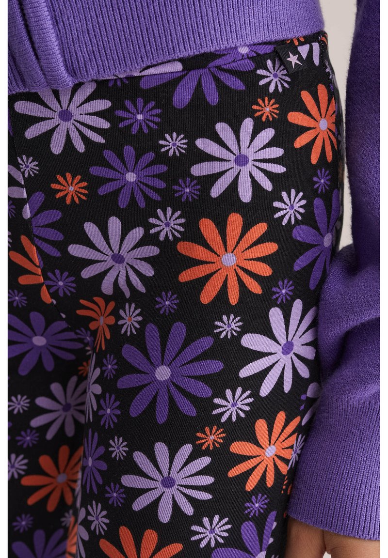 Leggings noirs avec un motif floral comprenant des fleurs violettes, oranges et blanches. Fabriqués en tissu doux et extensible avec une coupe ajustée.