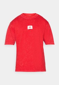 Rød kortærmet t-shirt lavet af bomuld med et falmet look. Har et mærke med et logo på forsiden og rund halsudskæring.
