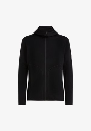 Musta vetoketjullinen huppari, jossa pitkähihaiset hihat, pehmeä kangas, korkea kaulus ja etusaumat. Minimalistinen muotoilu ja hillitty brändäys hihassa.