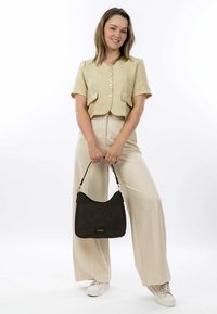 Short-sleeve beige linen top with front buttons, paired with cream wide-leg trousers. Brown textured handbag with decorative stitching.