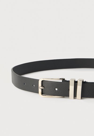 Μαύρη ζώνη από δέρμα με υφή, με ασημί ορθογώνια αγκράφα και δύο ασημένιες θηλιές ζώνης σε λευκό φόντο.