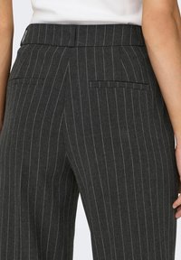 Pantaloni grigi a righe con una texture liscia, caratterizzati da un taglio dritto, due tasche posteriori e una vita sartoriale.