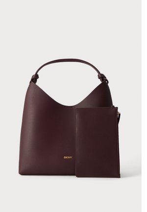 Mørkebrun skuldertaske i læder med matchende aftagelig pung og guld DKNY-logo på ensfarvet hvid baggrund.