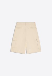 Short cargo beige vu de dos avec deux poches fentes à la taille et deux poches à rabat sur les côtés.