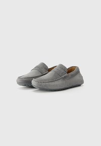 Mocasines de ante gris con detalles cosidos, suela de goma plana y diseño de fácil uso con una banda decorativa en la parte delantera.