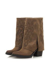 Bottines en daim marron avec un design fendu, des motifs courbés brodés et un talon empilé. Présente un logo discret sur le côté.