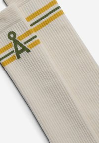 Elfenbeinfarbene, gerippte knielange Socken mit grünen und gelben Streifen sowie einem stilisierten grünen Logo. Weicher, strukturierter Stoff mit elastischem Abschluss.