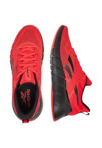 Punased sportlikud kingad hingava võrkkattega, mustade aktsentidega, paksu tallaga ja struktureeritud disainiga stabiilsuse ja toe tagamiseks.