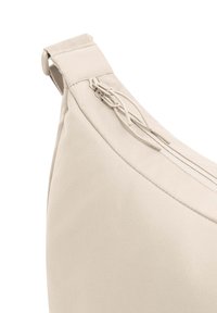 Borsa in tessuto beige dalla forma curva, con chiusura a zip e superficie texturizzata. Include una tracolla robusta e dettagli di design minimalisti.