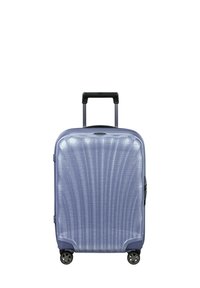 Hard-shell suitcase in light blue, featuring a textured surface with vertical lines, retractable handle, and four spinner wheels.