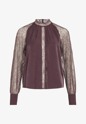 Burgundia blus, millel on õhulised pitsist pikad varrukad ja kõrge kaelus. Omab sujuva kangaga esipaneeli ning seljal on võtmeauk.