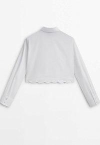 Chemisier blanc court à manches longues, col avec encolure et ourlet festonné. Confectionné dans un tissu lisse et léger.