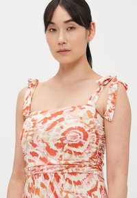 Φόρεμα με λουλουδάτο σχέδιο σε απαλό, ελαφρύ ύφασμα. Διαθέτει παστέλ αποχρώσεις ροζ και πορτοκαλί, με ριγέ τιράντες και εφαρμοστή σχεδίαση κορσέ.