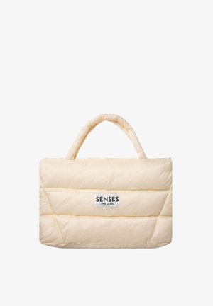 Padded cream tote bag with two rounded handles, featuring horizontal quilted sections and a brand logo label on the front.