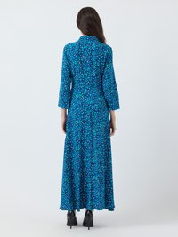 Μπλε φλοράλ μακρύ φόρεμα με μεγάλα μανίκια, ψηλό γιακά και ρέουσα σιλουέτα, διακοσμημένο με σχέδιο από μικρά, πολύχρωμα λουλούδια.