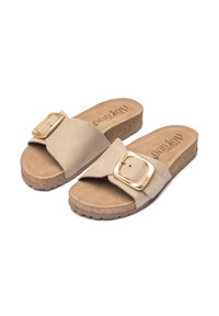 Sandales à bride glissante beiges avec une tige en daim, semelle intérieure en liège et semelle en caoutchouc texturé. Présente un grand détail de boucle carrée en ton doré.