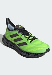 Scarpa da corsa verde brillante con suola in lattice stampato in 3D nera, lacci neri e tre strisce nere sul lato.