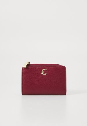 Burgundy leather wallet with a textured finish, featuring a gold logo accent, top zipper closure, and compact rectangular shape.