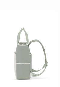 Mochila de tela verde claro con un diseño elegante. Cuenta con correas ajustables, acentos en blanco y bolsillos laterales para almacenamiento conveniente.