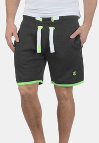 Shorts atletici gri cu accente verzi, șnururi albe și un detaliu mic cu logo. Confectionați dintr-un material moale, prezentând o potrivire confortabilă.