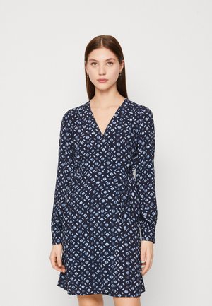 Μπλε ναυτικό φόρεμα τύπου wrap με μακριά μανίκια, με σχέδιο διαμαντιών σε φωτεινές μπλε αποχρώσεις και βαθύ λαιμόκοψα. Φτιαγμένο από ελαφρύ ύφασμα.