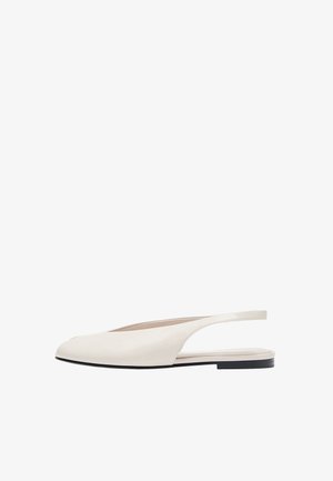 Chaussure plate slingback couleur crème avec bout pointu et semelle noire, design minimaliste, vue de côté sur fond blanc.