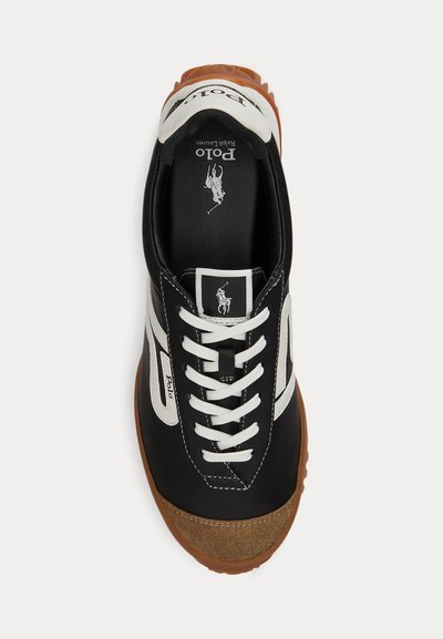 Ασπρόμαυρο αθλητικό παπούτσι Polo Ralph Lauren με καφέ σόλα, λευκά κορδόνια και λογότυπο Polo στη γλώσσα και την πλευρά, σε θέαση από πάνω.