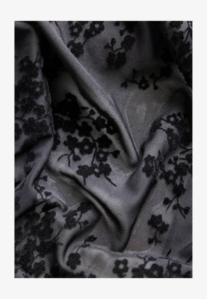 Tela de encaje floral negra drapeada, con una superficie texturizada y flores negras dimensionales sobre un fondo gris. Apariencia detallada y con capas.