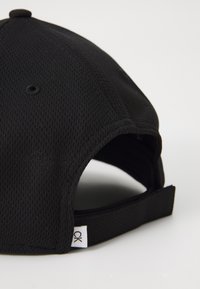 Μαύρο καπέλο μπέιζμπολ με υφή διχτυού, με καμπυλωτό γείσο και ρυθμιζόμενη ζώνη. Μικρή ετικέτα με "CK" στο πλάι.