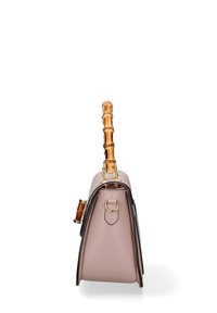 Roze synthetische handtas met een gestructureerd ontwerp, bamboe handgreep, gouden hardware accenten en een ronde basis, voorzien van contrasterende donkere randen.