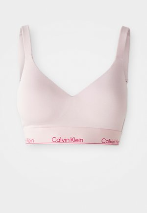 Bralette rose clair en tissu lisse et extensible, avec un décolleté en V et une large bande arborant le logo "Calvin Klein" en rose.