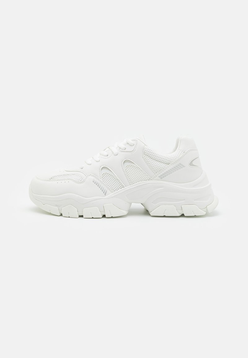 White athletic sneakers featuring a mesh upper with leather accents, textured rubber sole, and a chunky design with notable contours.