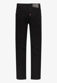 Jeans en denim noir au design droit, style cinq poches, avec un patch logo visible près de la ceinture. Texture lisse.