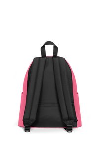 Mochila con un exterior rosa y correas y acentos negros. Incluye un asa superior, dos bolsillos laterales y una textura de tela suave.