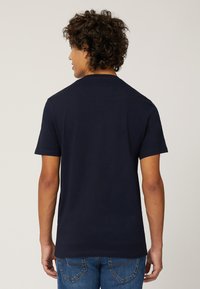 Marineblauwe katoenen T-shirt met korte mouwen, ronde hals en standaard pasvorm. Heeft een gladde textuur en een eenvoudig ontwerp zonder graphics.