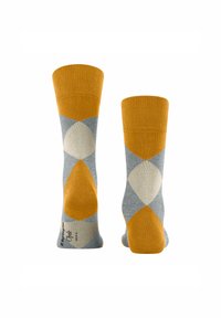 Calze con un design geometrico che presenta sezioni alternate di giallo senape e grigio, con audaci forme a diamante e bordi a coste.