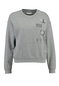 Grijze sweatshirt van zachte stof met een ronde hals. Beschikt over geborduurde badges, waaronder een vlag, en decoratieve stiksels op de zomen.