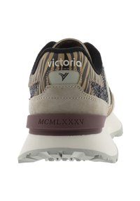 Les baskets présentent un dessus en textile rayé beige et noir, des accents en daim, un capuchon de talon bordeaux et une semelle en caoutchouc blanche avec des détails de traction.