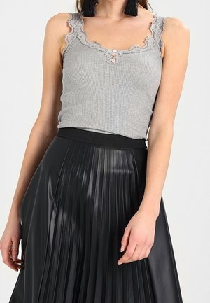 Szary prążkowany top bez rękawów z koronkowym wykończeniem i guzikami, zestawiony z czarną plisowaną spódnicą z sztucznej skóry, posiadającą szeroki elastyczny pas.