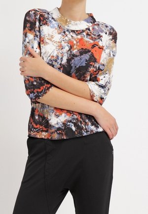 Mehrfarbiges Oberteil mit abstrakten Mustern in Rot, Blau, Schwarz und Gold. Hergestellt aus glattem Stoff mit rundem Ausschnitt und Dreiviertelärmeln.