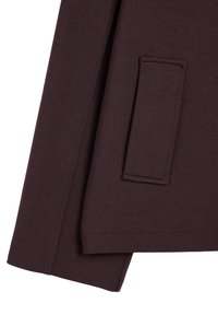 Ciempurpurowy, teksturowany materiał o prostym kroju. Posiada kieszeń łataną po lewej stronie rękawa. Prosty, uporządkowany design.