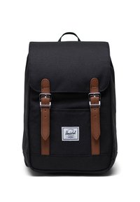 Czarny plecak z tkaniny z brązowymi skórzanymi paskami i metalowymi klamrami. Posiada przednią kieszeń, naszywkę z logo oraz uchwyt na górze do noszenia.
