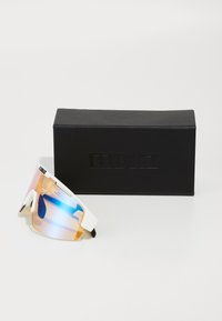 Sportsonnenbrille mit einem weißen Rahmen und verspiegelten orangen Verlaufslinsen, neben einer schwarzen rechteckigen Box mit geprägt eingearbeitetem Markenlogo präsentiert.