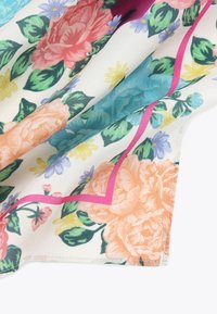 Tessuto con motivo floreale che presenta grandi fiori rosa, arancioni e blu con foglie verdi, accentuato da un disegno a zigzag rosa su uno sfondo chiaro.