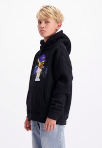 Zwarte hoodie met een voorzak en grafisch ontwerp van een cartoonfiguur. Zachte stof, ontspannen pasvorm en een verstelbare trekkoordkap.