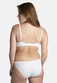 Ensemble de lingerie blanche en tissu lisse et extensible, avec des bretelles réglables à motif texturé et une fermeture à crochets au dos.