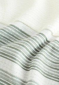 Tissu avec des rayures alternées en vert et crème, tissé avec une finition texturée, mettant en valeur un aspect doux et superposé.