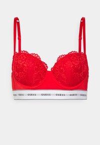 Reggiseno balconette rosso in pizzo con coppe sagomate, spalline rosse regolabili e una banda bianca con il logo "GUESS" ripetuto.