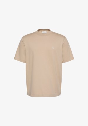Beige short-sleeve crewneck T-shirt with small white "cK" logo on left chest and Calvin Klein Jeans label inside collar.