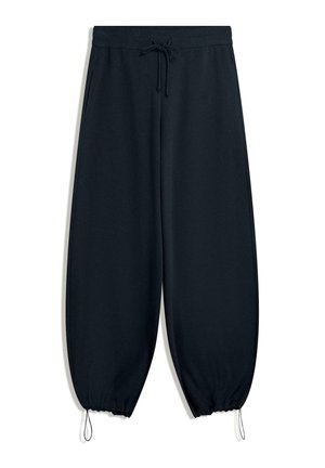 Pantalon de survêtement noir, coupe ample, taille élastiquée, fermeture à cordon, poches latérales et serrages réglables aux poignets.
